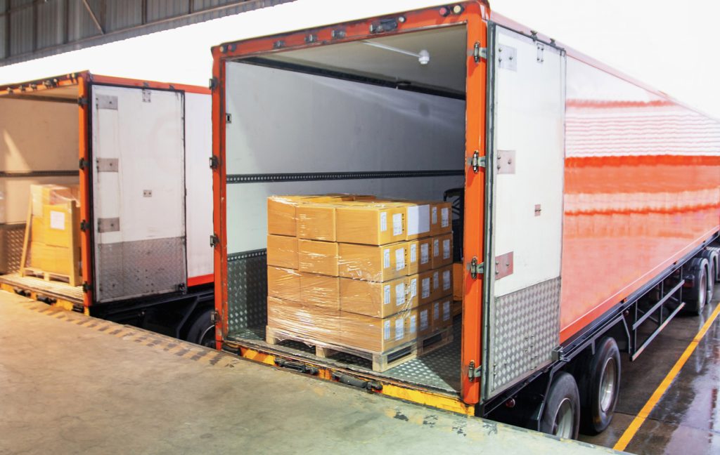Road freight warehouse industry logistics and transportation. Truck loading cargo shipment goods into container truck.